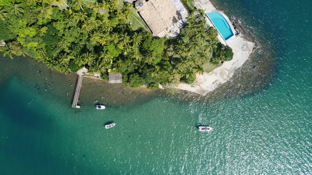 ariel view of hotel with lush green trees and clear sea waters