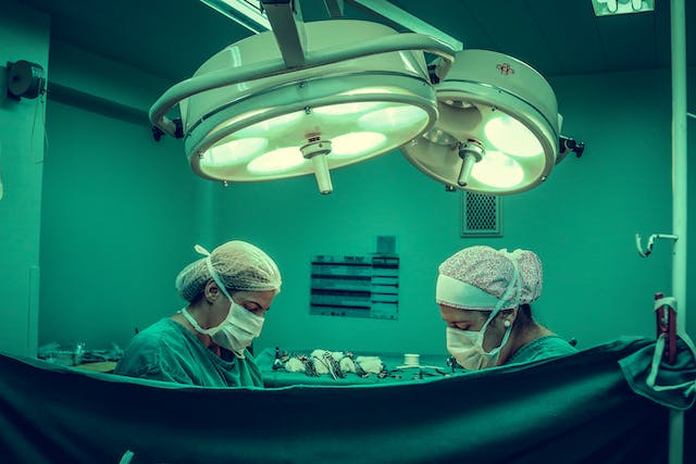 NHS operating theatre with lights, showing the need to reduce carbon emissions