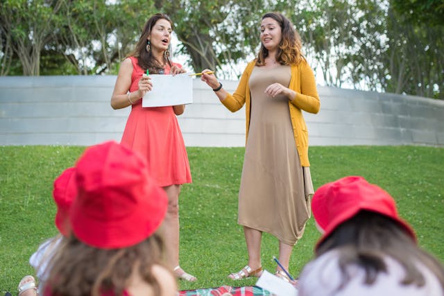 teachers standing in the school garden talking to children